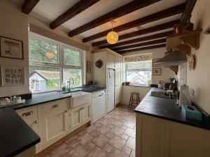 a large kitchen with white cabinets and black counter tops at Elegant 4-Bed Pet-Friendly Retreat in Snowdonia in Conwy
