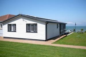 une maison blanche avec vue sur l'océan dans l'établissement 15 Golden Bay Holiday Village - Coastal Retreat with Breathtaking Views, à Westward Ho