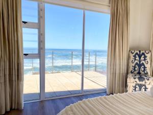 ein Schlafzimmer mit Bett und Blick auf das Meer in der Unterkunft Waterfront Seafront cottage C3 in Swakopmund