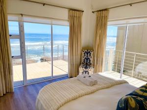 ein Schlafzimmer mit Bett und Blick auf das Meer in der Unterkunft Waterfront Seafront cottage C3 in Swakopmund