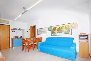 a living room with a blue couch and a table at Corallo Cavallino in Cavallino-Treporti