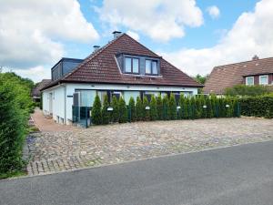 a white house with a fence in front of it at Strandnahe & hochwertige Ferienunterkunft, mit Gartenzugang, Parkplatz und Fahrradunterstellplatz in Scharbeutz