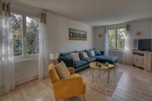 a living room with a blue couch and a table at Calme absolu détente en famille & Piscine chauffée in La Tremblade