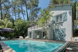 a swimming pool in front of a house at Calme absolu détente en famille & Piscine chauffée in La Tremblade