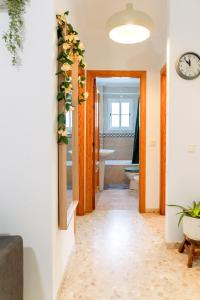Un pasillo con un baño con bañera y reloj. en Melosas Loft - HOME RENT MALAGA, en Torre del Mar 17 fotos más