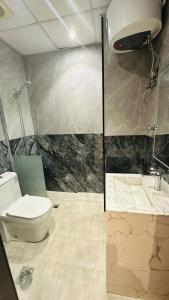 un baño con inodoro y ducha en فندق مسار الأمل الذهبي - أثمان سابقاً, en Al ‘Azīzīyah