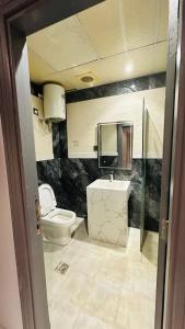 un baño con inodoro y lavabo en فندق مسار الأمل الذهبي - أثمان سابقاً, en Al ‘Azīzīyah 7 fotos más
