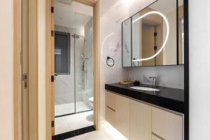 a bathroom with a shower and a sink and a mirror at 故渝里两室两卫 in Chongqing