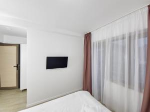 a hotel room with a bed and a window at La Oprescu in Azuga