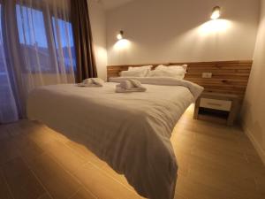 a bedroom with a large bed with two towels on it at La Oprescu in Azuga