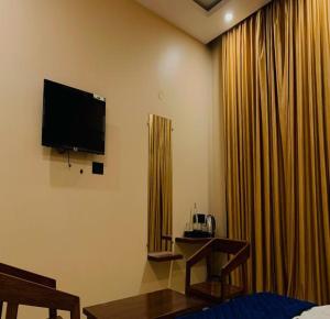 a hotel room with a television and curtains at AuroBESHA in Puducherry Airpoert