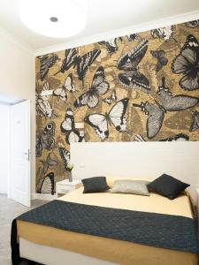 una camera da letto con una parete rivestita di carta da parati a farfalle di Velvet Suite a Roma