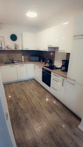 cocina con armarios blancos y suelo de madera en Ferienwohnung Bergblick, en Marquartstein 9 fotos más