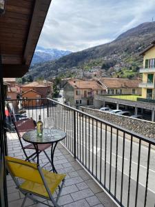a table and chairs on a balcony with a view at Casa Mauro in Gravedona