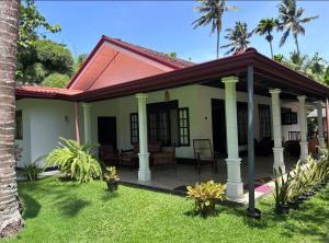 a house with a porch with palm trees at coco haven in Habaraduwa