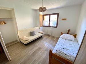 La Plagne TarentaiseにあるAppartement 4 personnes Versant du Soleilのベッドとソファのある部屋