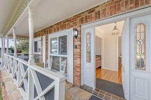 a brick house with a white door and a staircase at Whisper on the Falls in Wentworth Falls