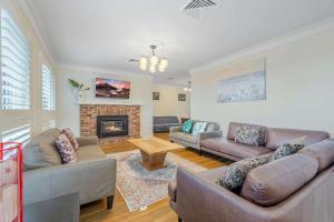 a living room with couches and a fireplace at Whisper on the Falls in Wentworth Falls