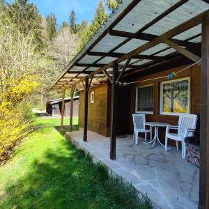 un patio con tavolo e sedie sotto un pergolato di Campingplatz & Bungalowdorf am Waldbad a Erlau