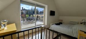 a bedroom with a bed and a large window at La Terrasse de Villeneuve in Villeneuve-sur-Yonne