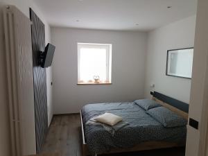 a small bedroom with a bed and a window at Casa Nadia - Val di Sole Apartment in Piano