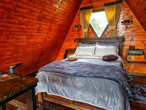 a bedroom with a bed in a log cabin at Glamping Hakuna Matata in Monguí