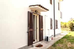 a white house with brown shutters and a door at A casa di Marco Guesthouse 2 - Apt di Ciampino e stazione per Roma in Marino