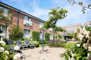威根Wrightington Hotel & Health Club的建筑物前有椅子的庭院