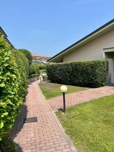 a brick walkway in front of a building with bushes at Residenza Kristall Lago in Desenzano del Garda