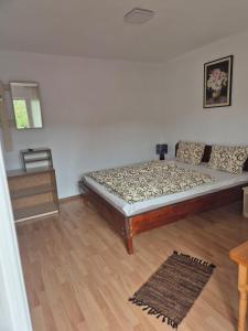 una camera da letto con un letto e un pavimento in legno di Pensiunea CORIMEN Vadu Crisului a Vadu Crişului