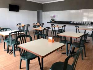 a restaurant with tables and chairs in a room at Hotel Alvorada in Batatais