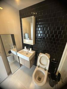 Un baño con un inodoro blanco y un lavabo. en The Room Sukhumvit 64 Punnawithi, en Phra Khanong