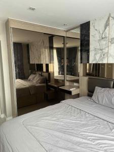 Un dormitorio con una cama y un espejo grande. en The Room Sukhumvit 64 Punnawithi, en Phra Khanong