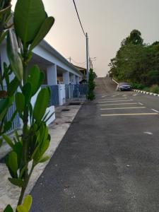a road with a building and a car parked on the side at Homestay Pinggiran Kota Kuantan in Kuantan