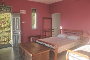 a bedroom with a bed and a red wall at Hotel SkyFall in Haputale +18 photos