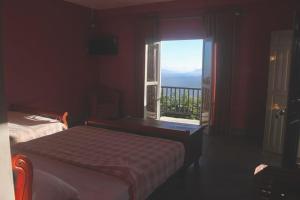a bedroom with a bed and a window with a view at Hotel SkyFall in Haputale