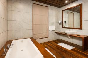a bathroom with a tub and a sink and a mirror at La Muraille, Galle Fort in Galle +66 photos