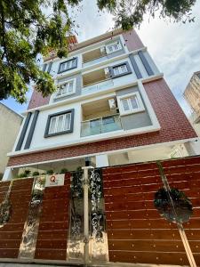 a building with a fence in front of it at Q by Kolam - Women and Family Serviced Apartments, Thoraipakkam, OMR in Chennai