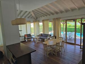 a living room with tables and chairs and a patio at Villa Casablanca with private pool in Lozenets