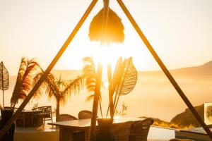 a table and chairs with the sunset in the background at Divino Caldera in Akrotiri