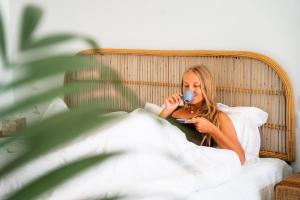 a woman laying in bed with a cup in her mouth at Divino Caldera in Akrotiri
