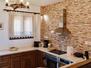 a kitchen with a stove top oven next to a brick wall at Villa Panorama Serenity 