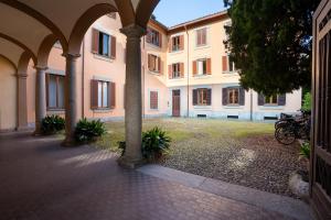 an empty courtyard of a building with columns and plants at Garavaglia Uno in Pavia