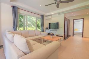 a living room with a couch and a table at Solario Beachfront Villa - Koh Chang in Ko Chang