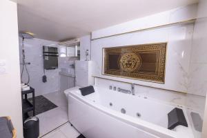 a bathroom with a tub and a gold plaque on the wall at Duplex suite 50m de la plage Carré d'Or Nice in Nice