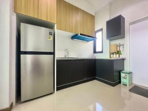 - un réfrigérateur en acier inoxydable dans une cuisine avec des placards en bois dans l'établissement Thann Villa by EThan Aonang, à Ao Nang Beach