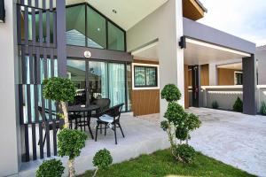 une maison avec une table et des chaises noires sur une terrasse dans l'établissement Thann Villa by EThan Aonang, à Ao Nang Beach