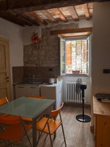 a kitchen with a table and chairs and a window at Affittacamere In centro in Gubbio