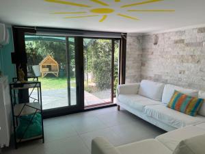 a living room with a white couch and a large window at Angel Home Steps from the Sea in Nea Kallikrateia