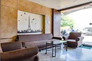 a living room with a couch and a table at FabHotel Surbhi in Bhopal +19 photos